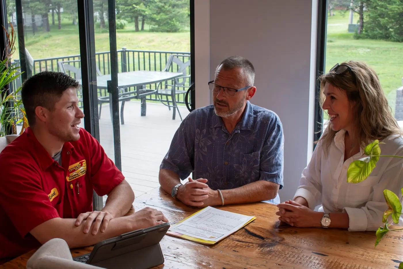 A Golden Rule System Engineer reviewing a replacement quote with homeowners at their kitchen table