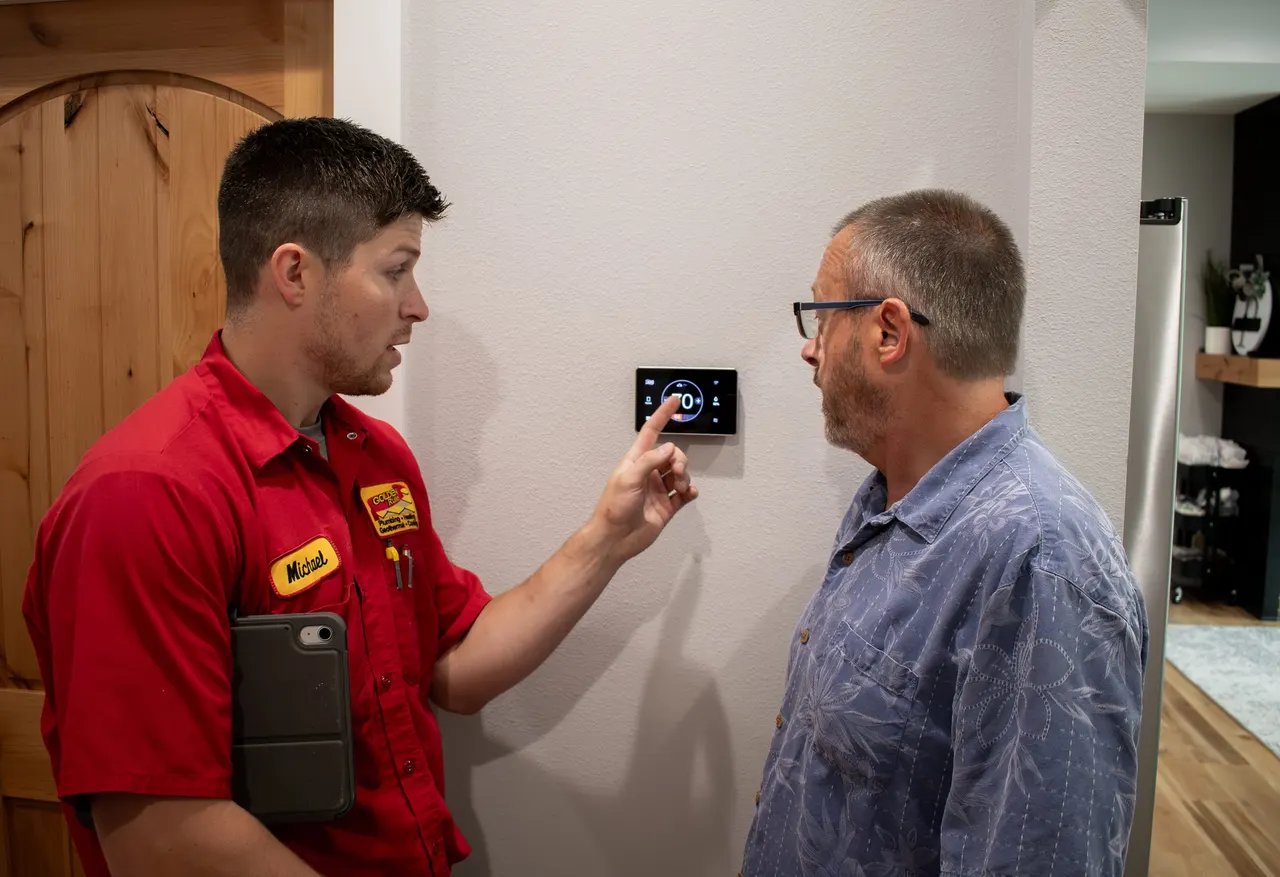 A Golden Rule technician walking a homeowner through their thermostat
