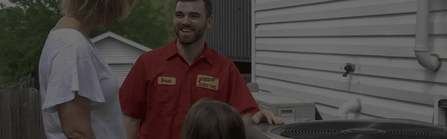 A Golden Rule technician with a family beside their outdoor AC unit