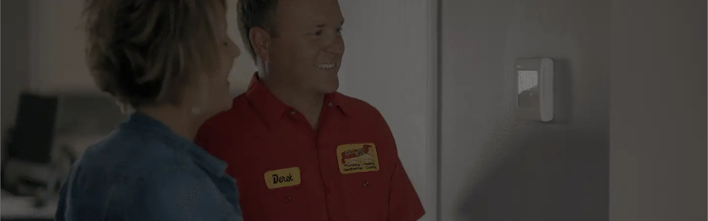 A Golden Rule technician showing a homeowner their thermostat settings